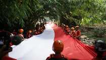 HUT RI, Askrindo Bentangkan Bendera Sepanjang 74 Meter di Ciliwung