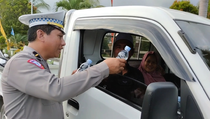 Polisi Bagikan Air Mineral kepada Pengendara yang Melintas di Trans Sulawesi
