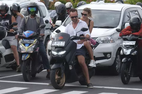 Turis asing mengendarai sepeda motor tanpa mengenakan helm di Jalan Sunset Road, Kuta, Badung, Bali, Selasa, 28 Februari 2023.