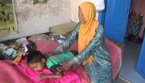 Calon jemaah haji Solati sedang memijat pasien anak-anak.