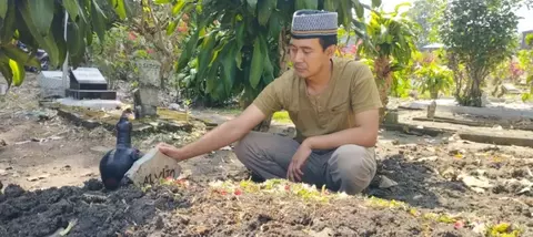 Imam Jazuli saat berada di makam anaknya Alvito korban meninggal dunia setelah disuntik perawat Rumah Sakit Prasetya Husada, Karangploso, Kabupaten Malang, Jawa Timur.