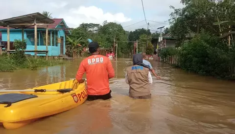 Warga melintas di tengah banjir di Kabupaten Penajam Paser Utara, Kalimantan Timur, Sabtu 22 Juli 2023.