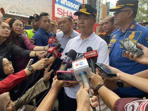 Penjabat Gubernur Jakarta Teguh Setyabudi (tengah) memberi keterangan pers setelah meninjau kebakaran Glodok Plaza, Jakarta Barat, Sabtu (18/1/2025).