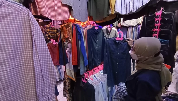 Pengunjung memilih pakaian bekas di pasar loak Cimol Gedebage, Bandung, Jawa Barat, Minggu, 26 September 2021. Membeli baju bekas bermerek menjadi sebuah gaya hidup untuk mengurangi limbah busana bagi sebagian orang. 

