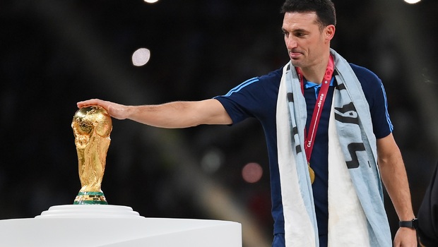 Pelatih Argentina, Lionel Scaloni, mengusap trofi Piala Dunia.