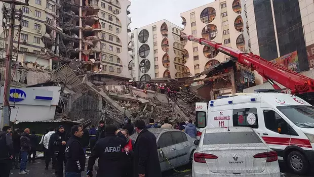 Petugas penyelamat dan tim medis berusaha menjangkau warga yang terjebak di bangunan yang runtuh setelah gempa bumi di Diyarbakir, Turki, Senin, 6 Februari 2023.