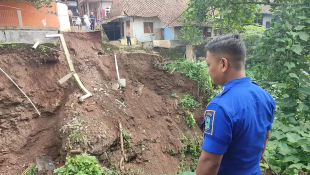 Petugas memperhatikan tebing penahan tanah (TPT) setinggi 35 meter yang longsor di kawasan Cikentrung, Kecamatan Kuningan, Jawa Barat.