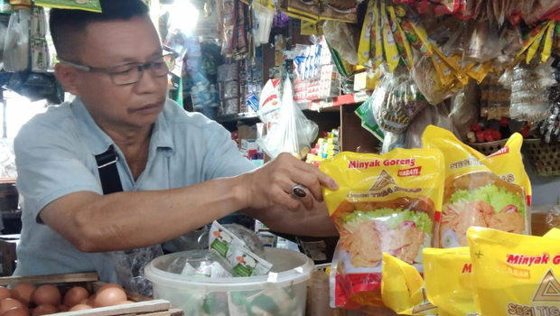 Salah seorang pedagang tengah merapikan minyak goreng di Pasar Gudang Tigaraksa, Tangerang, Senin, 20 Februari 2023.