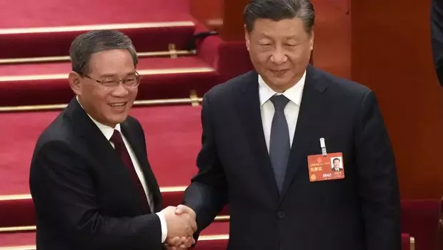 Perdana Menteri baru terpilih Li Qiang berjabat tangan dengan Presiden Tiongkok Xi Jinping selama sesi Kongres Rakyat Nasional China (NPC) di Aula Besar Rakyat di Beijing, Sabtu, 11 Maret 2023.