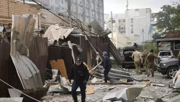 Seorang petugas polisi dan petugas penyelamat berjalan di depan restoran RIA Pizza yang hancur akibat serangan Rusia di Kramatorsk, Ukraina, Selasa, 27 Juni 2023.
