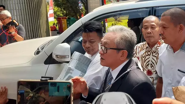Maqdir Ismail (kaca mata) pengacara dari Irwan Hermawan, terdakwa perkara korupsi BTS Bakti Kominfo, membawa uang tunai bernilai US$ 1,8 juta atau setara Rp 27 miliar ke Kejaksaan Agung, Kamis, 13 Juli 2023.