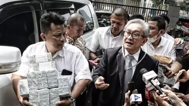 Pengacara terdakwa kasus dugaan korupsi base transceiver station (BTS) Irwan Hermawan, Maqdir Ismail (kanan) bersama timnya, diitanyai wartawan saat tiba di Gedung Bundar, Kejaksaan Agung, Jakarta, Kamis 13 Juli 2023.