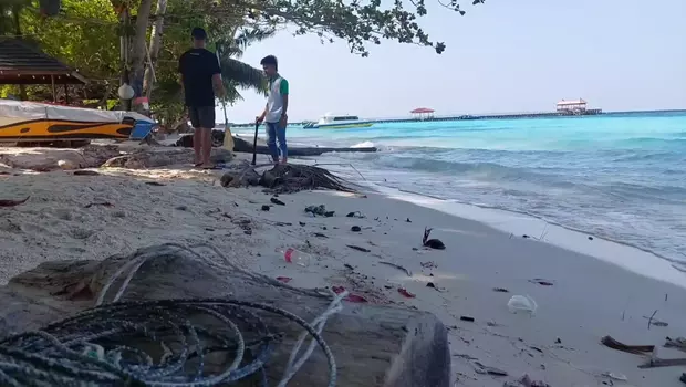 Sejumlah pekerja tengah membersihkan sampah di kawasan pantai Pulau Maratua, Kabupaten Berau, Kalimantan Timur, Senin, 4 September 2023.