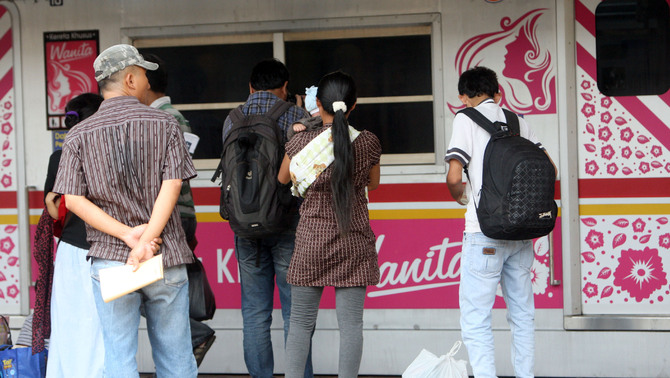 Calon penumpang berdiri disamping  rangkaian KRL khusus perempuan yang berhenti di Stasiun Pasar, Senen, Jakarta. FOTO: Yudhi Sukma Wijaya / JAKARTA GLOBE
