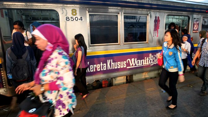 Penumpang berjalan melintasi rangkaian KRL khusus perempuan yang berhenti di Stasiun Manggarai, Jakarta. FOTO: Joanito De Saojoao/ SUARA PEMBARUAN