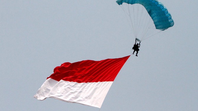 Prajurit TNI membawa bendera merah putih saat terjun free fall dari ketinggi 8000 kaki pada acara gladi bersih upacara peringatan ke-67 Hari Jadi TNI tahun 2012 di Bandara Halim Perdanakusuma, Jakarta. FOTO: Ruht Semiono/ SUARA PEMBARUAN