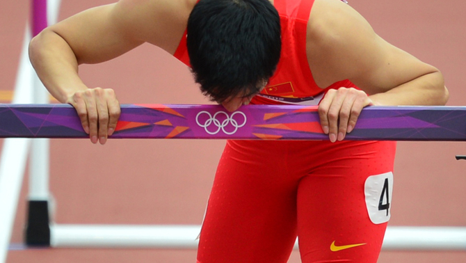 Atlet China Liu Xiang berlari  mencium garis gawang saat melintasi lintasan pada lari gawang 110 meter putera di Olimpiade London 2012. FOTO:  AFP PHOTO / GABRIEL BOUYS
