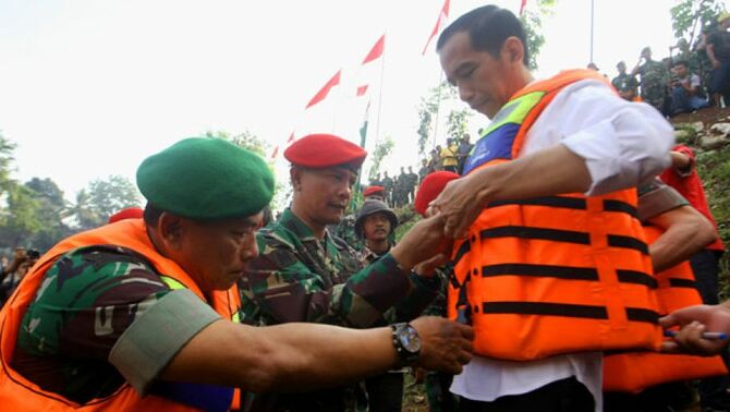 KSAD Jenderal TNI Moeldoko (kiri) membantu memakaikan rompi pelampung kepada Gubernur DKI Jakarta Joko Widodo, saat bersiap menaiki perahu karet untuk  menyusuri sungai Ciliwung dikawasan Kalibata, Jakarta Selatan, Rabu (14/8).