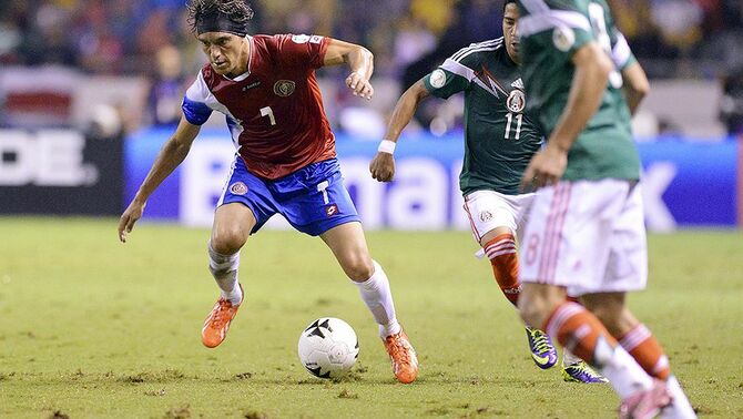 Pemain Kostarika, Cristian Bolanos (kiri) dibayangi oleh pemain Meksiko, Javier Aquino dalam pertandingan kualifikasi FIFA World Cup 2014 Concacaf di stadion Nacional, San Jose, Selasa(15/10). Kostarika unggul dengan skor 2-1 atas Meksiko dalam pertandingan kualifikasi tersebut.