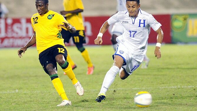 Pemain Jamaika, Demar Phillips (kiri) dan pemain Honduras, Andy Ariel Rodriquez Najar beradu bola dalam pertandingan kualifikasi CONCACAF World Cup 2014 di Kingston, Jamaika, Selasa (15/10). Kedua kesebelasan bermain dengan hasil skor imbang 2-2 sampai peluit babak kedua dibunyikan.