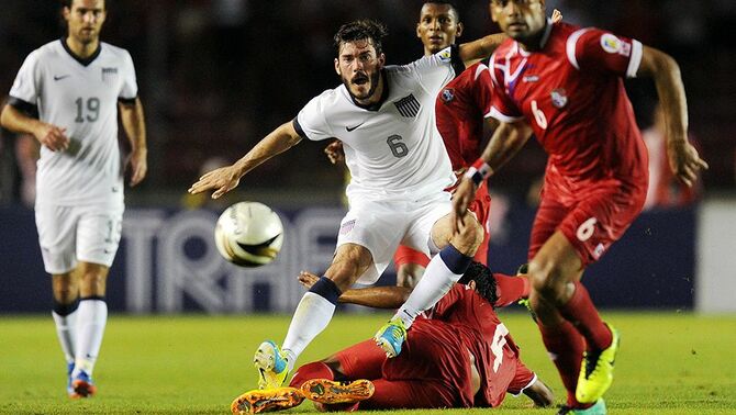 Pemain Amerika Serikat, Brad Evans (tengah) saat beradu bola dengan pemain Panama, Gabriel Gomez (kanan) dalam babak kualifikasi FIFA World Cup 2014 Concacaf di stadion Rommel Fernandez, Panama, Selasa (15/10).