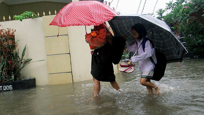 Anak sekolah melintasi banjir saat pulang sekolah dikawasan Kel. Gedong, Kec. Pasar Rebo, Jakarta Timur, Rabu (13/11). Curah hujan yang tinggi di Jakarta membuat beberapa wilayah di Jakarta terendam banjir.
