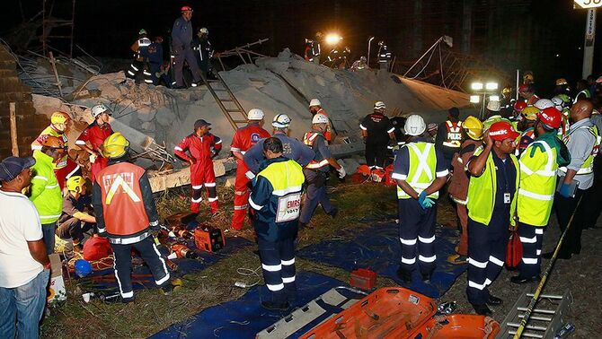 Tim penyelamat mencari para korban yang terperangkap di reruntuhan bangunan pusat perbelanjaan dekat kota Durban, Afrika Selatan, Selasa, 19 November 2013.