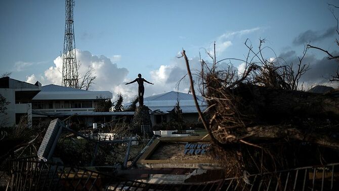 Sebuah patung berdiri diantara reruntuhan kota yang dilanda topan Haiyan, 8 November 2013 lalu.