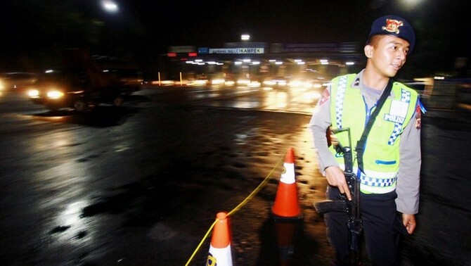 Anggota Polisi mengatur lalu lintas di Cikampek, Jawa Barat, Jumat (25/7) malam.