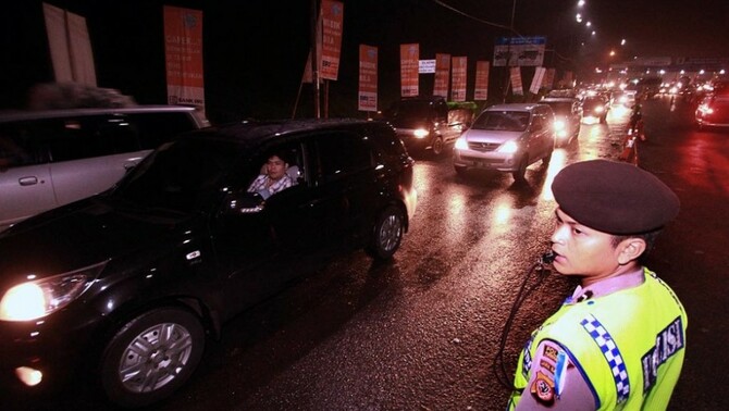 Anggota Polisi mengatur lalu lintas di Cikampek, Jawa Barat, Jumat (25/7) malam.