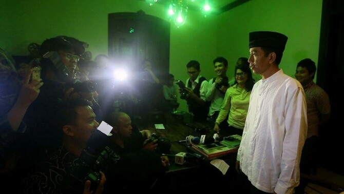 Presiden terpilih Indonesia, Joko Widodo (kanan) berpose di depan wartawan di kediamannya, di Solo, Jawa Tengah, Sabtu (26/7).