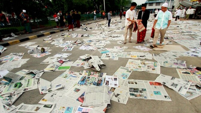 Sampah kertas koran menutupi jalan usai digunakan untuk pelaksanaan Sholat Idul Fitri di Pelabuhan Sunda Kelapa, Jakarta, Senin (28/7). Umat muslim Indonesia merayakan Hari Raya Idul Fitri 1 Syawal 1435 H pada hari Senin, 28 Juli 2014. BeritaSatu Photo/Ruht Semiono