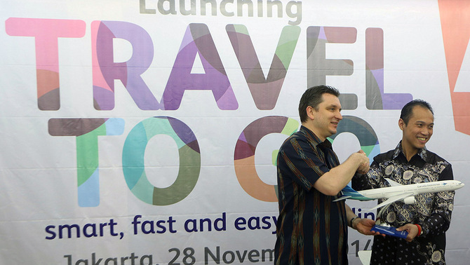 Direktur Pemasaran & Penjulan Garuda Indonesia Erik Meijer (kiri) meyerahkan cendera mata kepada  Presiden direktur Modern Seven Eleven Indonesia Henri Honoris usai penanatanganan kerja sama di gerai Seven Eleven, kawasan Blok M, Jakarta Selatan, Jumat (28/11).