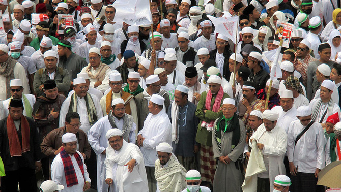 Habib Rizieq (tengah bawah, mengangkat tangan) nampak memberikan arahan kepada koordinator aksi long march di depan Plaza Indonesia, Jalan MH Thamrin, Jakarta Pusat, Senin (1/12).