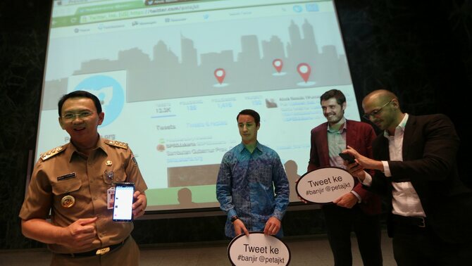 Gubernur DKI Jakarta Basuki T Purnama (kiri) menunjukan tweet pertamanya menggunakan aplikasi PetaJakarta.org kepada Director of Academic Partnership Twitter Mark Gillis (dua kiri), Direktur Proyek Tomas Holderness (kedua kanan) dan Direktur Proyek Etienne Turpin (kanan) pada peluncurannya di Balai Kota, Jakarta, Selasa (2/12/2014). 