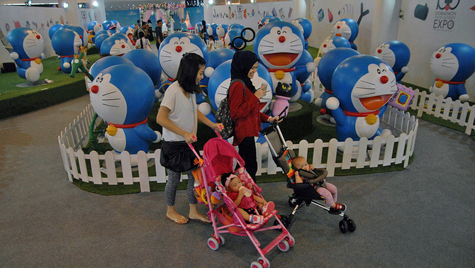 Anak kecil melihat-lihat diorama tokoh animasi robot kucing Doraemon pada pembukaan 