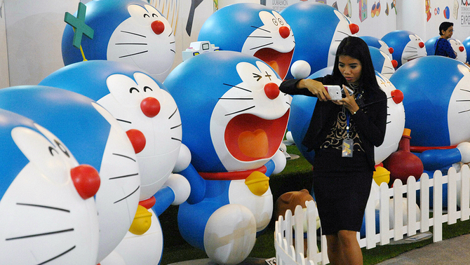 Anak kecil melihat-lihat diorama tokoh animasi robot kucing Doraemon pada pembukaan 
