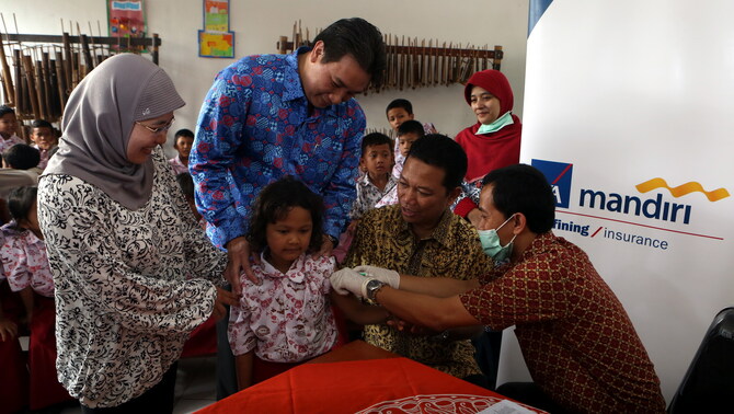 Presiden Direktur AXA Life Indonesia Hengky Djojosantoso, Kepala Seksi Pencegahan dan Pemberantasan Penyakit Menular Dinas Kesehatan Bogor dr. Siti Robiah dan General Manager Vaccines Sanofi Group Indonesia Joko Murdianto menyaksikan pemberian vaksinasi typhoid secara cuma-cuma kepada siswa-siswi SDN Loji 3 Bogor, Jawa Barat