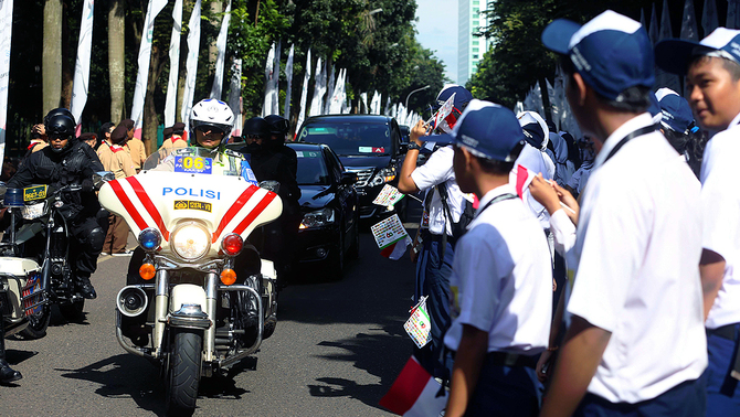 Pelajar menyambut pemimpin negara, tamu peserta  Konferensi Tingkat Tinggi Asia Afrika di depan Jakarta Convention Center, 22 April 2015.