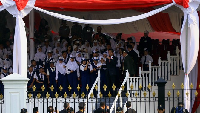 Presiden RI Joko Widodo menyaksikan atraksi seni memperingati HUT ke-70 Kemerdekaan Indonesia bersama siswa siswi paduan suara dari berbagai sekolah menengah pertama,di  Istana Merdeka, Jakarta, Senin (17/8).