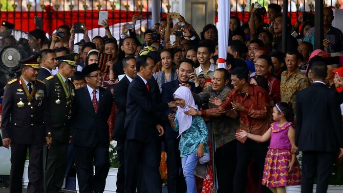 Presiden Joko Widodo (keempat kiri) bersama Panglima Jenderal TNI Gatot Nurmantyo (kedua kiri), Kapolri Jenderal Pol.Badrodin Haiti (kiri) serta Mensesneg Pratikno (ketiga) menyalami warga yang diundang dalam Peringatan HUT ke-70 Kemerdekaan Indonesia di Halaman Istana Merdeka, Jakarta, Senin (17/8). 