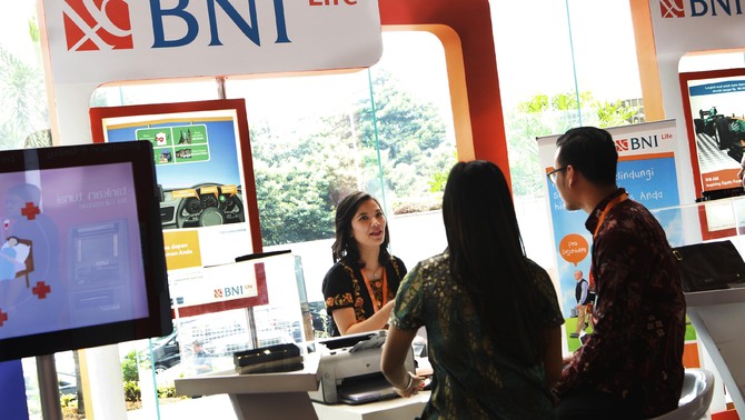 Petugas menawarkan produk asuransi dari BNI Life kepada pengunjung disela  acara BNI Subsidiaries Expo 2015 di lobi utama Kantor Pusat BNI, Jakarta, Senin (26/10/2015).