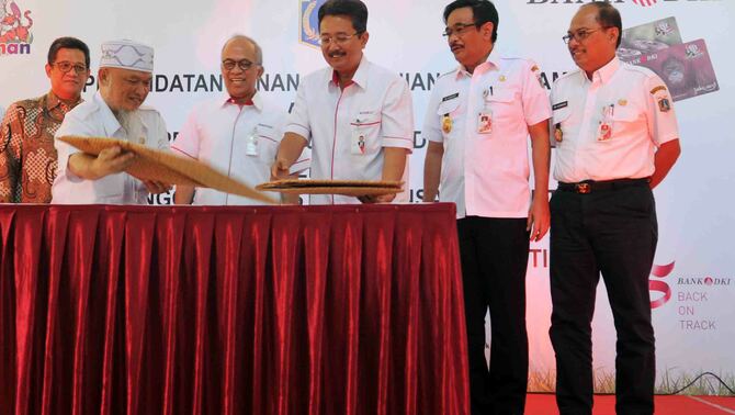 Direktur Bisnis Bank DKI, Antonius Widodo (ketiga kanan) bertukar naskah kerjasama dengan Kepala Kantor Pengelola TMR Bambang Triana (kedua kiri) disaksikan Direktur Utama Bank DKI, Kresno Sediarsi (ketiga kiri), Wakil Gubernur DKI Jakarta  Djarot Saiful Hidayat (kedua kanan) dan Walikota Jakarta Selatan Tri Kurniadi saat penandatanganan kerjasama pemakaian e-ticketing JakCard Bank DKI di Taman Margasatwa Ragunan, Jakarta, Rabu (4/5/2016). BeritaSatu Photo/Mohammad Defrizal