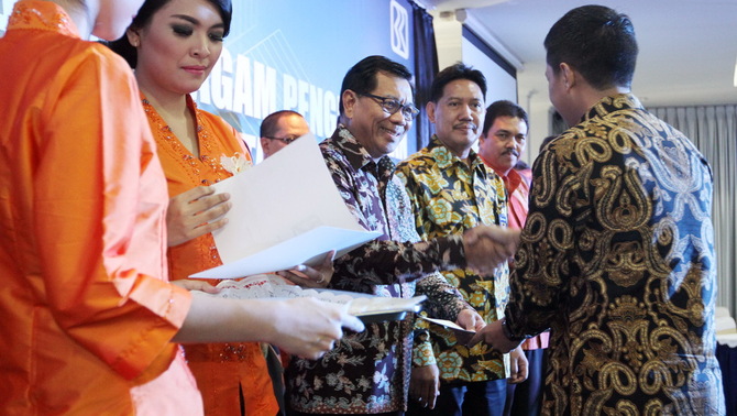 Direktur Utama PT Bank Rakyat Indonesia Tbk Asmawi Syam bersama Direktur Kuswiyoto, dan Pemimpin Wilayah BRI Jakarata 1 Budi Satria memberikan penghargaan mengembangkan bisnis mikro kepada karyawan berprestasi di sela acara Program Penghargaan BRI Unit (PPBU) di kantor BRI Jakarta 1, Jakarta

