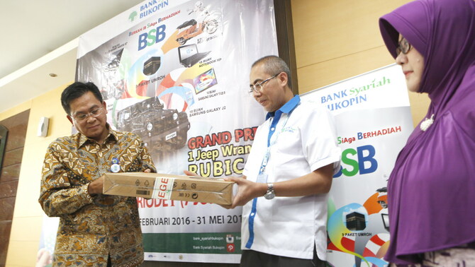 Direktur PT Bank Syariah Bukopin Aris Wahyudi (kiri) dibantu Kepala Divisi Pengembangan Produk Noor Cholis, membuka kotak berisi laptop yang disegel saat penarikan Tabungan Berhadiah Program Berkah iB SiAga Berhadiah Periode ke-1 (pertama) bertempat di kantor pusat BSB, Salemba, Jakarta, Selasa 7 Juni 2016.
