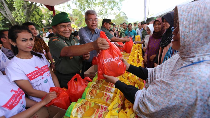 Danpussenif Kodiklat TNI AD, Prihadi Agus Irianto (kiri) bersama Direktur Corporate Affair Sinar Mas, Lukmono Sutarto (kanan) melayani warga membeli  minyak goreng murah pada acara Bazaar Rakyat di Komplek Kodiklat Pusat Pendidikan Infantri (Pussenif) Bandung, Jawa Barat, Jumat 17 Juni 2016. 