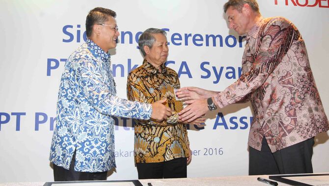 Presiden Direktur BCA Syariah John Kosasih (kiri) didampingi Direktur BCA Suwignyo Budiman (tengah) menjabat tangan  Presiden Direktur Prudential Indonesia Jens Reisch usai penandatanganan kerjasama BCA Syariah dengan Prudential Life Assurance di Jakarta, Senin (28/11).
