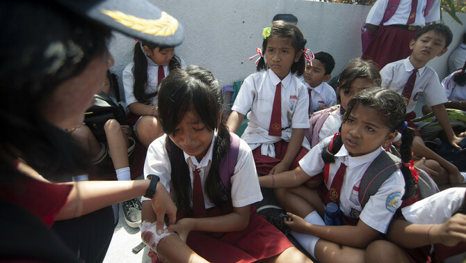 Petugas medis menangani siswa yang terluka saat simulasi gempa bumi dan tsunami di Tanjung Benoa, Badung, Bali, 15 Agustus 2017.