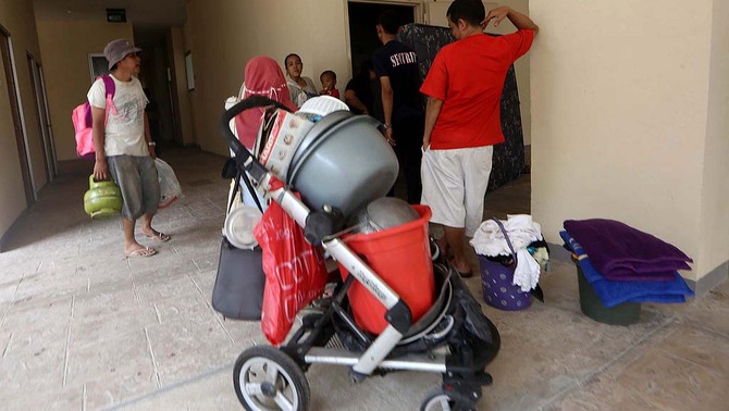 Sejumlah warga kampung pulo membawa barang-barang rumah tangga untuk di pindahkan ke rumah susun Jatinegara barat, saat terjadi penggusuran di bantaran kali Ciliwung kampung pulo, Jatinegara, Jakarta Timur, 20 Agustus 2015.