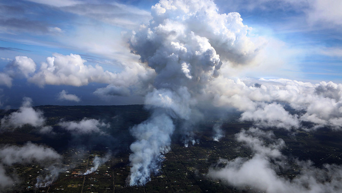 Asap yang bercampur gas muncul dari permukaan tanah dampak aktivitas vulkanik gunung Kilauea di beberapa titik di wilayah perkebunan Leilani, Pulau Besar, Hawaii.